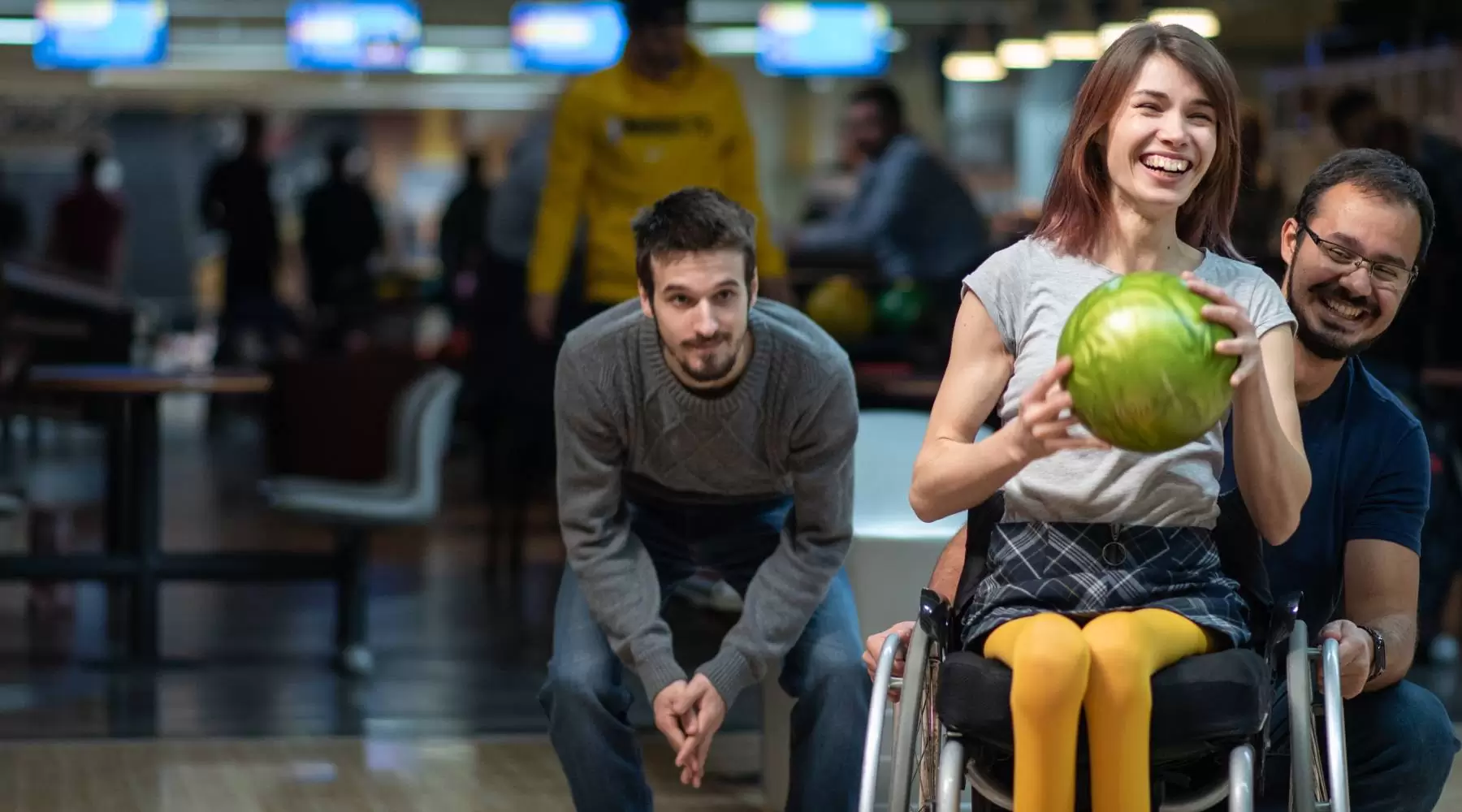 Woman in a wheelchair bowling with friends